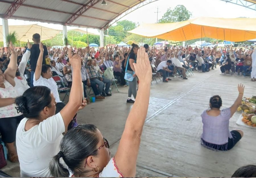 Asamblea comunitaria en Paso del Correo, Papantla, con decenas de personas levantando la mano para votar